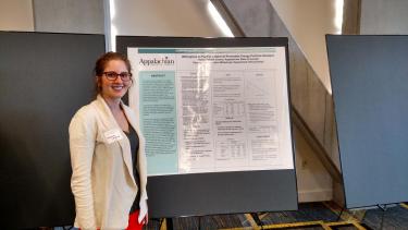 undergraduate student researcher with poster presentation